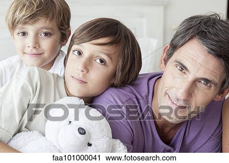 Stock Image - "Father with young boys, portrait". Fotosearch