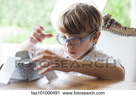 Stock Image - Little boy building house of cards. Fotosearch
