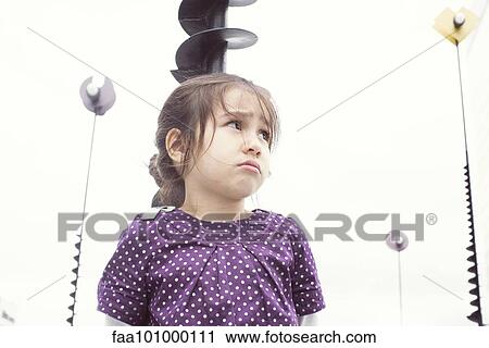 Stock Image - Little girl outdoors with sulky expression. Fotosearch