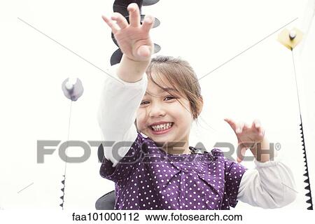 Stock Image - "Little girl playing outdoors, portrait". Fotosearch