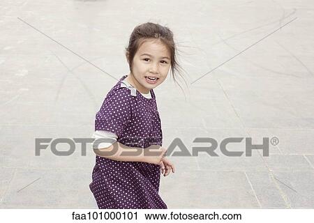 Stock Image - Little girl smiling outdoors. Fotosearch