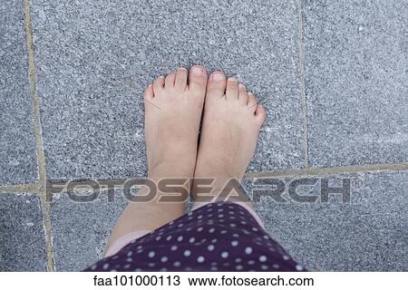 Stock Image - "Little girl's bare feet, overhead view". Fotosearch