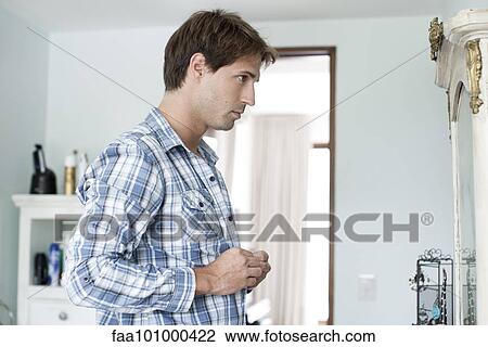 Man buttoning shirt View Large Photo Image Stock Image - Man buttoning shirt. Fotosearch