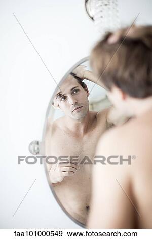 Stock Photo - Man examining hairline in mirror. Fotosearch