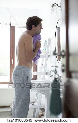 Man in bathrom drying face with towel View Large Photo Image Stock Photography - Man in bathrom drying face with towel. Fotosearch