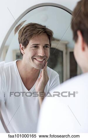 Man looking at self in mirror admiring facial stubble View Large Photo Image Stock Photography - Man looking at self in mirror admiring facial stubble. Fotosearch