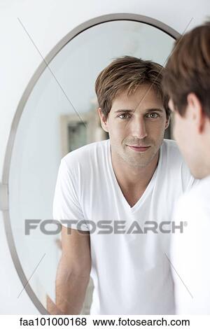 Stock Photo - Man looking at self in mirror. Fotosearch