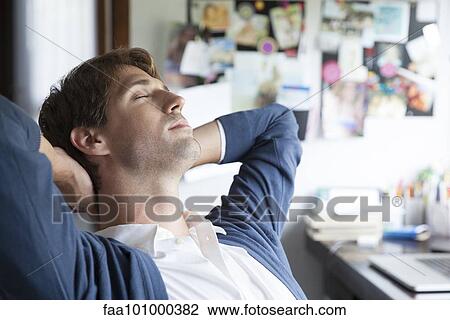 Man relaxing in home office View Large Photo Image Stock Image - Man relaxing in home office. Fotosearch