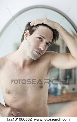 Man scrutinizing hairline in mirror View Large Photo Image Stock Image - Man scrutinizing hairline in mirror. Fotosearch