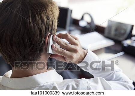 Stock Photo - "Man using cell phone, rear view". Fotosearch