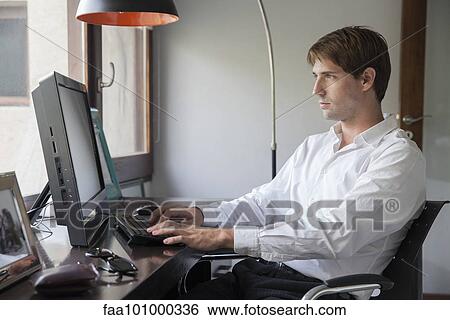 Stock Photograph - Man using desktop computer. Fotosearch