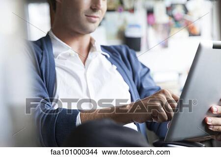 "Man using digital tablet, cropped" View Large Photo Image Picture - "Man using digital tablet, cropped". Fotosearch