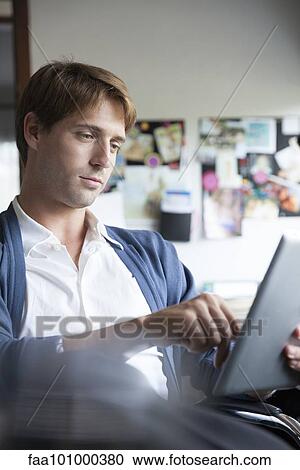 Man using digital tablet in office View Large Photo Image Stock Image - Man using digital tablet in office. Fotosearch