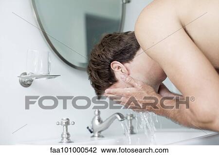 Man washing face in bathroom sink View Large Photo Image Stock Image - Man washing face in bathroom sink. Fotosearch
