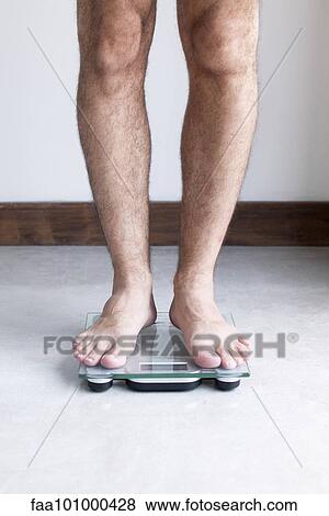 Man weighing self on bathroom scale View Large Photo Image Stock Photo - Man weighing self on bathroom scale. Fotosearch