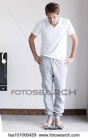 Man weighing self on bathroom scale View Large Photo Image Stock Photo - Man weighing self on bathroom scale. Fotosearch