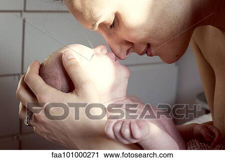 Stock Image - Mother nuzzling newborn baby. Fotosearch