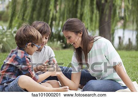 Mother teaching her sons how to thumb wrestle View Large Photo Image Stock Image - Mother teaching her sons how to thumb wrestle. Fotosearch