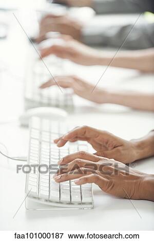 Stock Photo - "Office workers using computer keyboards, cropped". Fotosearch