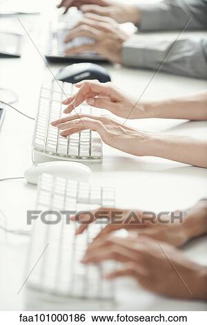 "Office workers using computer keyboards, cropped" View Large Photo Image Stock Photograph - "Office workers using computer keyboards, cropped". Fotosearch