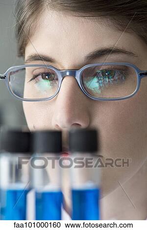 Stock Image - "Scientist looking at test tubes in lab, close-up". Fotosearch