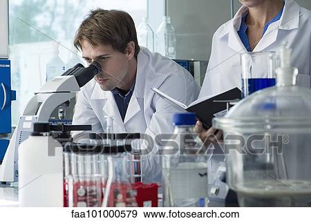 Scientist looking through microscope in laboratory View Large Photo Image Stock Photo - Scientist looking through microscope in laboratory. Fotosearch