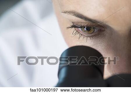 Stock Photo - "Scientist using microscope, close-up". Fotosearch