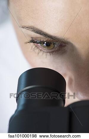 Stock Photo - "Scientist using microscope, close-up". Fotosearch