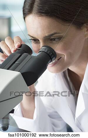 Stock Image - "Scientist using microscope in laboratory, close-up". Fotosearch