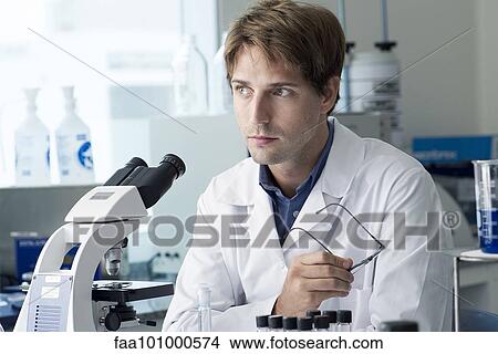 Picture - "Scientist working in laboratory, looking away in thought". Fotosearch