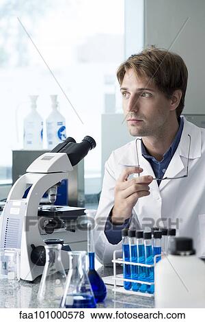 "Scientist working in laboratory, looking away in thought" View Large Photo Image Stock Photo - "Scientist working in laboratory, looking away in thought". Fotosearch