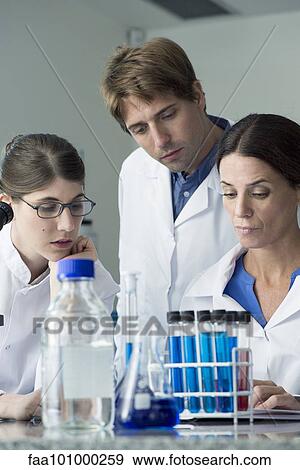 Scientists conducting experiment in laboratory View Large Photo Image Stock Photo - Scientists conducting experiment in laboratory. Fotosearch