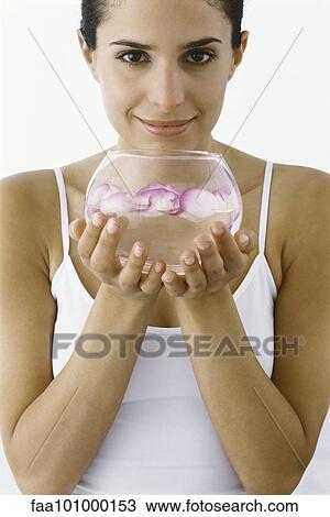 Woman holding bowl of petals floating in water View Large Photo Image Stock Image - Woman holding bowl of petals floating in water. Fotosearch