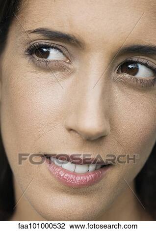 Stock Image - "Woman looking away, close-up of face". Fotosearch