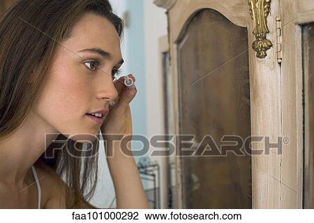 Stock Image - Woman putting on mascara. Fotosearch