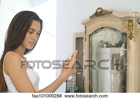 Woman putting on perfume View Large Photo Image Stock Photo - Woman putting on perfume. Fotosearch