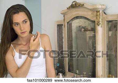 Woman putting on perfume View Large Photo Image Stock Photo - Woman putting on perfume. Fotosearch