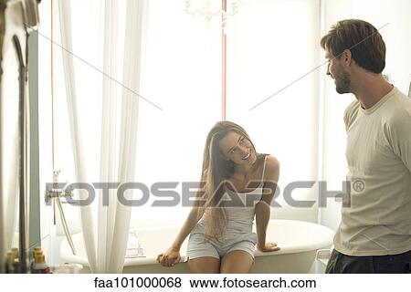Woman sitting on bathtub edge giving husband suggestive look View Large Photo Image Stock Photo - Woman sitting on bathtub edge giving husband suggestive look. Fotosearch