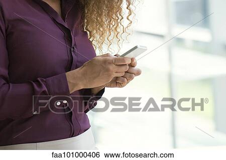 Woman text messaging with smartphone View Large Photo Image Stock Photograph - Woman text messaging with smartphone. Fotosearch