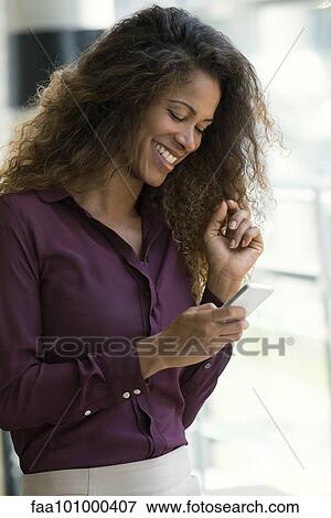 "Woman using smartphone, smiling" View Large Photo Image Stock Photo - "Woman using smartphone, smiling". Fotosearch