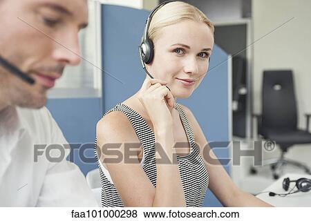 Woman wearing phone headset at desk View Large Photo Image Stock Photo - Woman wearing phone headset at desk. Fotosearch