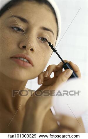 Stock Photo - "Young woman applying mascara, close-up". Fotosearch