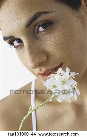 Picture - "Young woman holding white flowers, portrait". Fotosearch