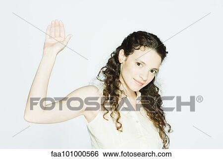 Stock Photograph - "Young woman raising hand, portrait". Fotosearch