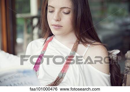 Stock Photograph - Young woman reading book. Fotosearch