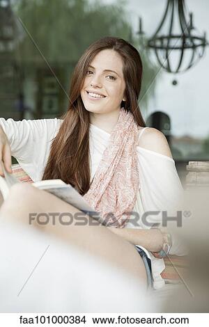 Picture - Young woman relaxing outdoors with book. Fotosearch