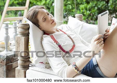 Young woman relaxing with digital tablet View Large Photo Image Stock Image - Young woman relaxing with digital tablet. Fotosearch