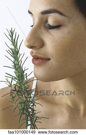 Stock Photo - "Young woman smelling spring of fresh rosemary, eyes closed". Fotosearch