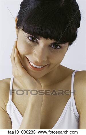 "Young woman touching cheek, smiling, portrait" View Large Photo Image Stock Image - "Young woman touching cheek, smiling, portrait". Fotosearch