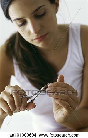 "Young woman trimming finger nails with nail scissors, close-up" View Large Photo Image Picture - "Young woman trimming finger nails with nail scissors, close-up". Fotosearch